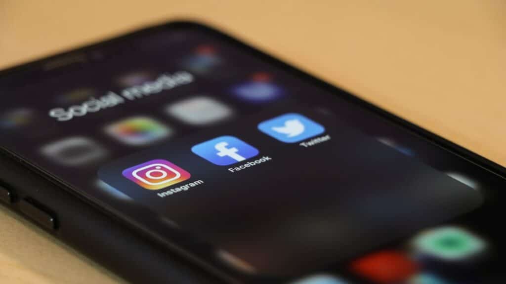 Teléfono móvil sobre una mesa de madera usado para gestionar contenido de redes sociales