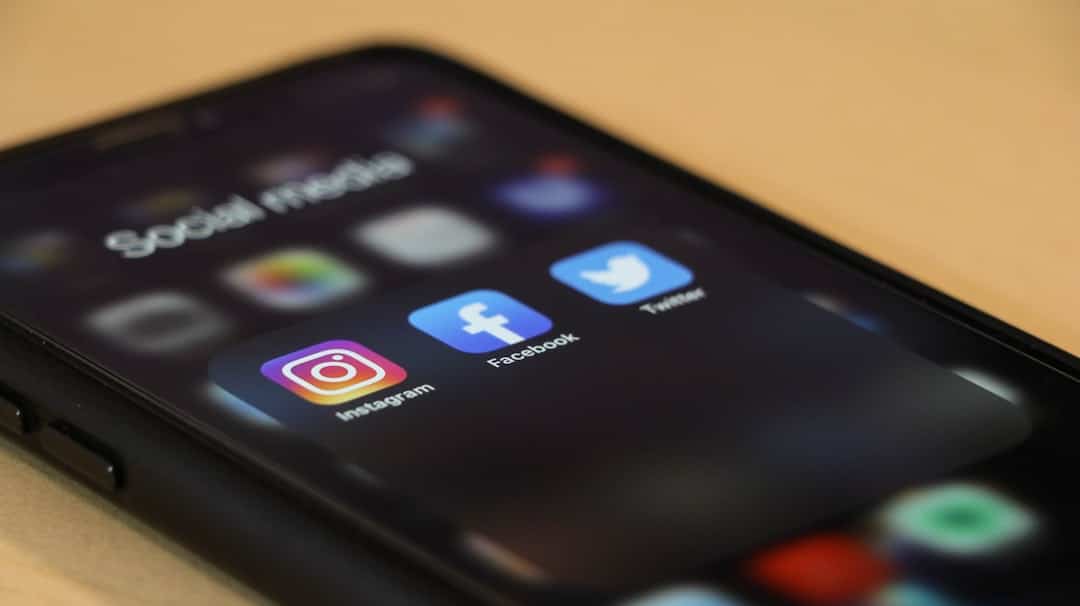 Teléfono móvil sobre una mesa de madera usado para gestionar contenido de redes sociales