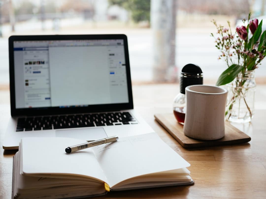Ordenador portátil y libreta sobre un escritorio usados para redactar contenido de marketing