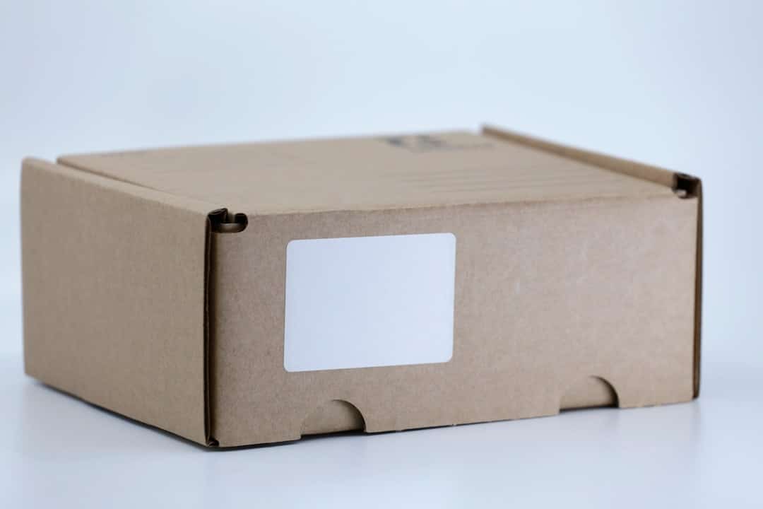 Caja de cartón de envío sobre una mesa blanca, representando una compra realizada en una tienda online